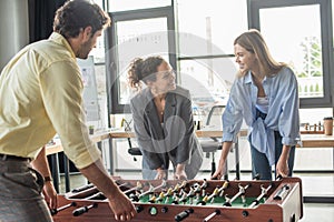 Smiling business people playing table soccer