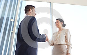 Smiling business people shaking hands at office
