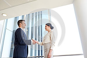 Smiling business people shaking hands at office