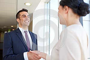 Smiling business people shaking hands at office