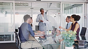 Smiling business people sharing document in meeting