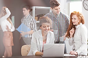 Smiling business people using laptop