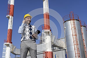Smiling Business Person in Yellow Hardhat Talking on Mobile Phone