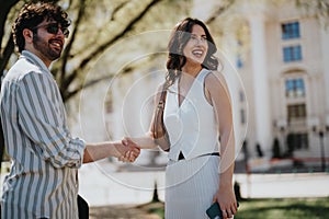 Smiling business professionals shaking hands outside a corporate building
