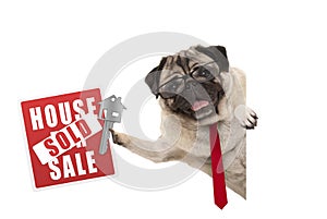 Smiling business pug dog with glasses and tie, holding up red house sold sign and key