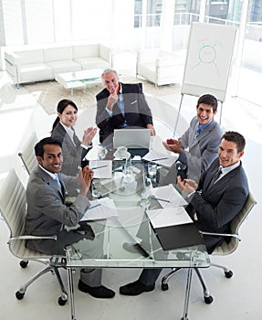 Smiling business team applauding in a meeting