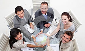 Smiling business team holding the world