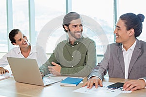 Smiling business team interacting with each other in conference room