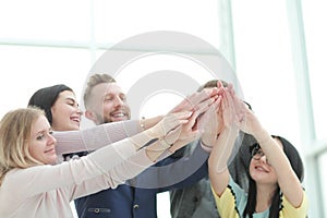 Smiling business team joining their hands together.