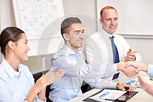 Smiling business team shaking hands in office