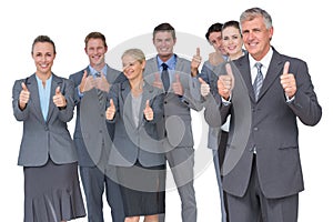 Smiling business team showing thumbs up
