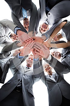 Smiling business team standing in circle hands together