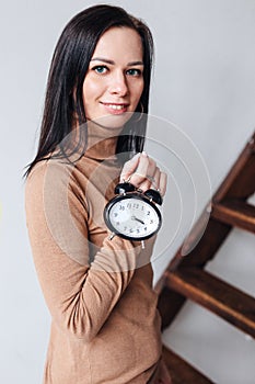 Smiling business woman hold alarm clock. Concept of saving time