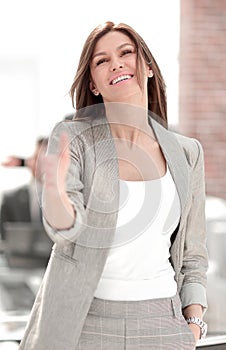 Smiling business woman holding out her hand for a handshake