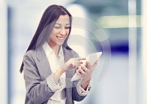 Smiling business woman holding a tablet computer at the office