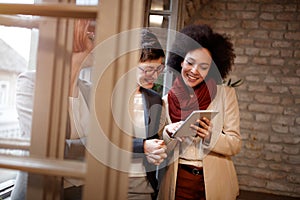 Smiling business woman looking at tablet on casual meeting photo