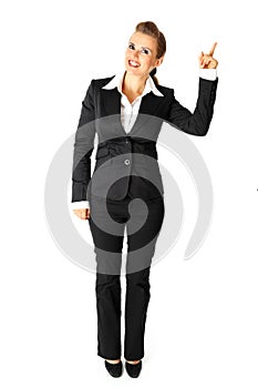 Smiling business woman pointing finger in corner