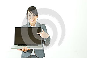 Smiling business woman pointing at laptop