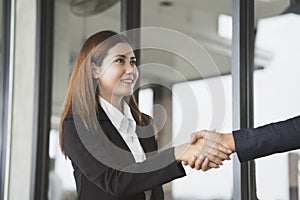 Smiling business woman shaking hands in the office building