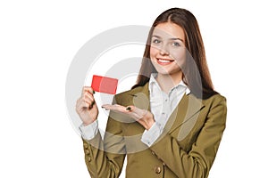 Smiling business woman showing blank credit card in green suit, over white background