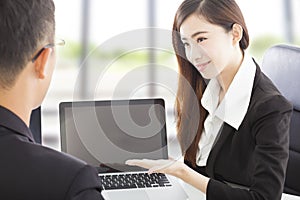 Smiling Business woman showing at laptop and explaining a plan