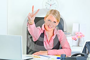 Smiling business woman showing victory