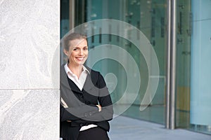 Smiling business woman standing outside office building