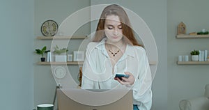 Smiling business woman talking mobile phone at home office. Portrait of joyful girl making phone call at remote