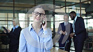 Smiling business woman talking on phone during work break, mobile conversation