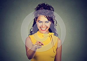 Smiling business woman in yellow dress pointing finger at viewer