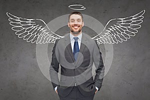 Smiling businessman with angel wings and nimbus