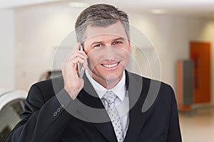 Smiling businessman calling with his mobile phone