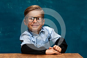 Smiling businessman child sitting at the table