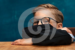 Smiling businessman child sitting at the table