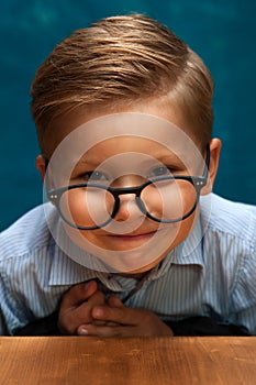 Smiling businessman child sitting at the table