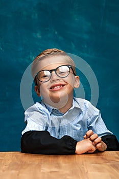 Smiling businessman child sitting at the table