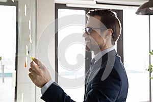 Smiling businessman develop business plan on office board