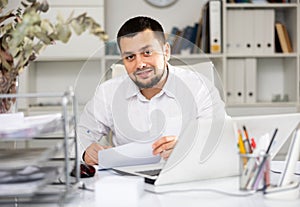 Smiling businessman doing his daily work in office