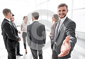 Smiling businessman gives hand for handshake