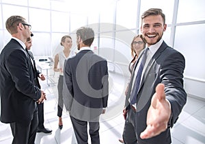 Smiling businessman gives hand for handshake