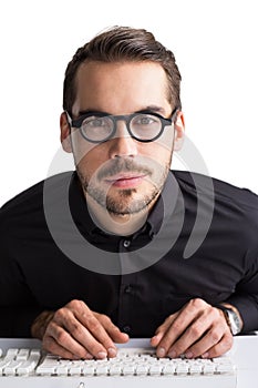 Smiling businessman with glasses typing on keyboard