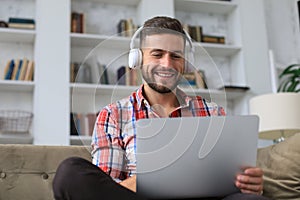 Smiling businessman greeting colleagues in video conference and negotiating distantly from home photo