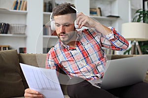 Smiling businessman greeting colleagues in video conference and negotiating distantly from home photo