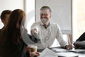 Smiling businessman handshake female colleague at business negotiations