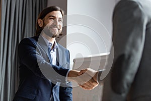 Smiling businessman handshake greeting with coworker at briefing