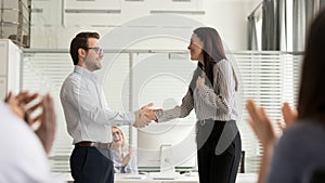 Smiling businessman handshake happy female employee greeting with success