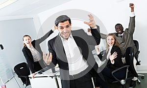 Smiling businessman with happy team at office