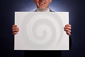 Smiling businessman holding a big blank card