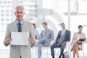 Smiling businessman holding a blank sign