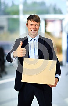Smiling businessman holding a cardboard box